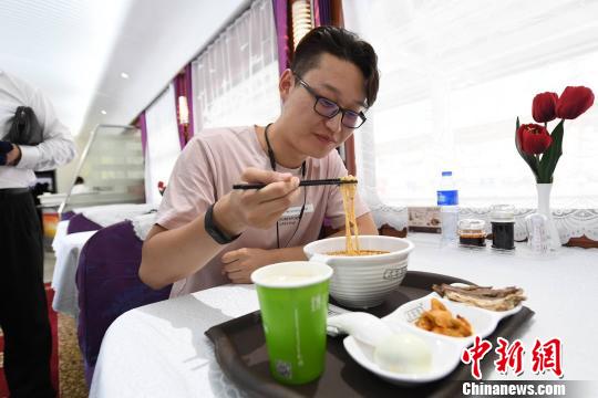 圖為旅客在列車上享用正宗牛肉面?！钇G敏 攝