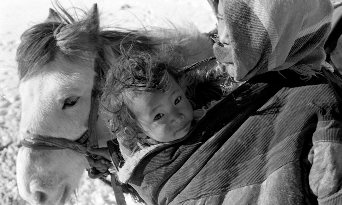 1990年3月，西藏當(dāng)雄縣納木湖鄉(xiāng)三村女牧民斯卓不畏嚴(yán)寒，懷抱幼子，準(zhǔn)備到遠(yuǎn)處放牧。新華社記者覺果攝