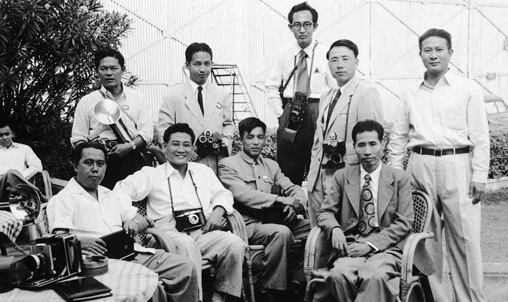 新華社記者錢嗣杰（站立者右二）在采訪會(huì)議開幕式后和外國記者在會(huì)場外休息。